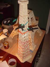 third section of the Eiffel Tower scroll saw wooden model held with elastic bands as it dries